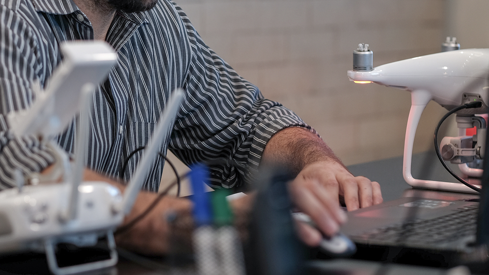 Profissional trabalhando com tecnologia de drones e software Maply